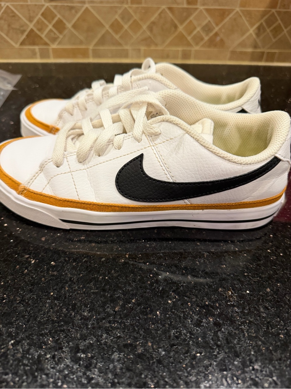 Nike Low-Top Sneakers size 6 in White with Black Swoosh and Gold Accent